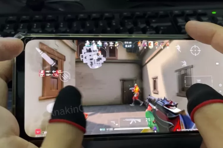 Cara Main Valorant di HP: Apakah Bisa? Info Resmi & Alternatif a person's feet on a television